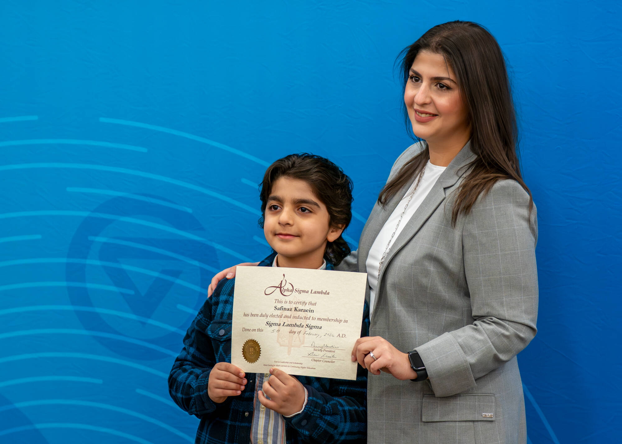 Nursing student Safinaz Karaein poses for a picture with son, Sammy Hasan, 7, during the Alpha Sigma Lambda Honor Society induction ceremony as part of the Sigma Lambda Sigma Chapter of GVSU on February 5.